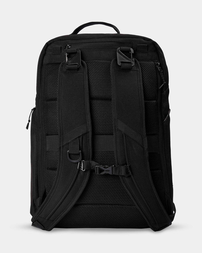 Black backpack with multiple straps and compartments on a light gray background