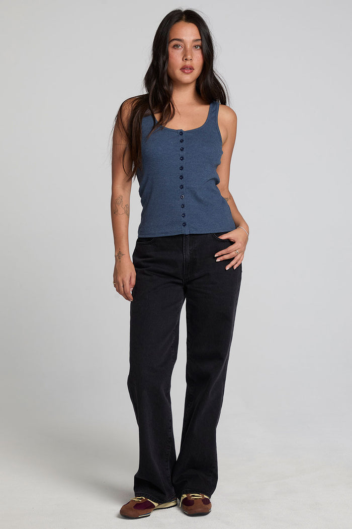 A full body front view of a woman wearing the Chaser Velora Dark Denim Tank on a neutral background with hand on hip