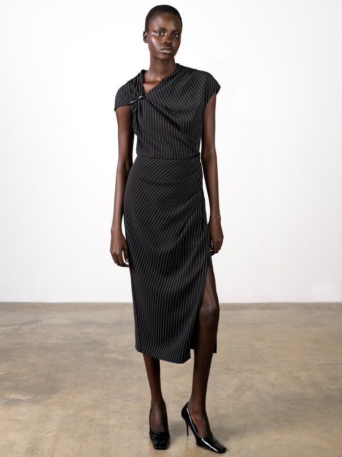 A woman wearing a pinstripe draped black midi dress with a draped neckline, short sleeves, a zip fastening and a side slit.