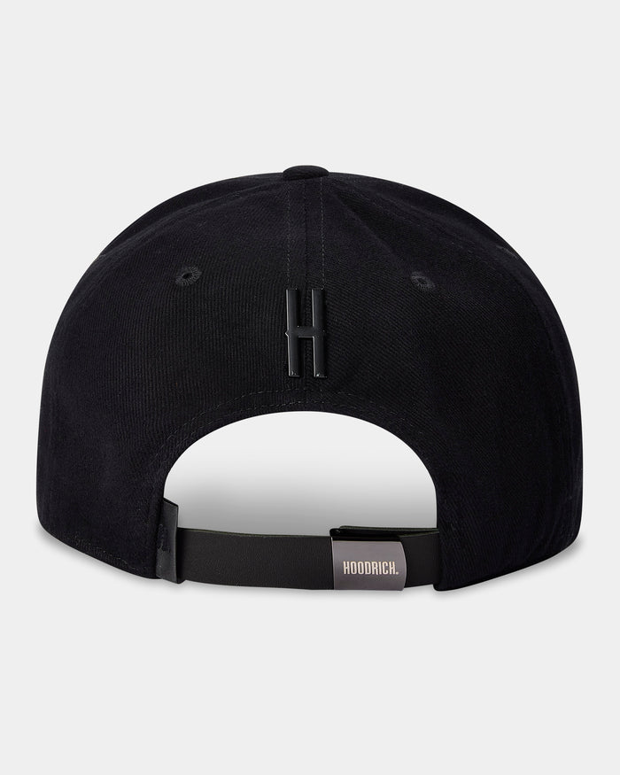 Black cap with a white patch and brand logo on a light gray background