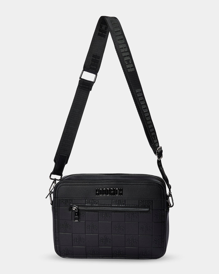 Black textured crossbody bag with a strap on a light gray background