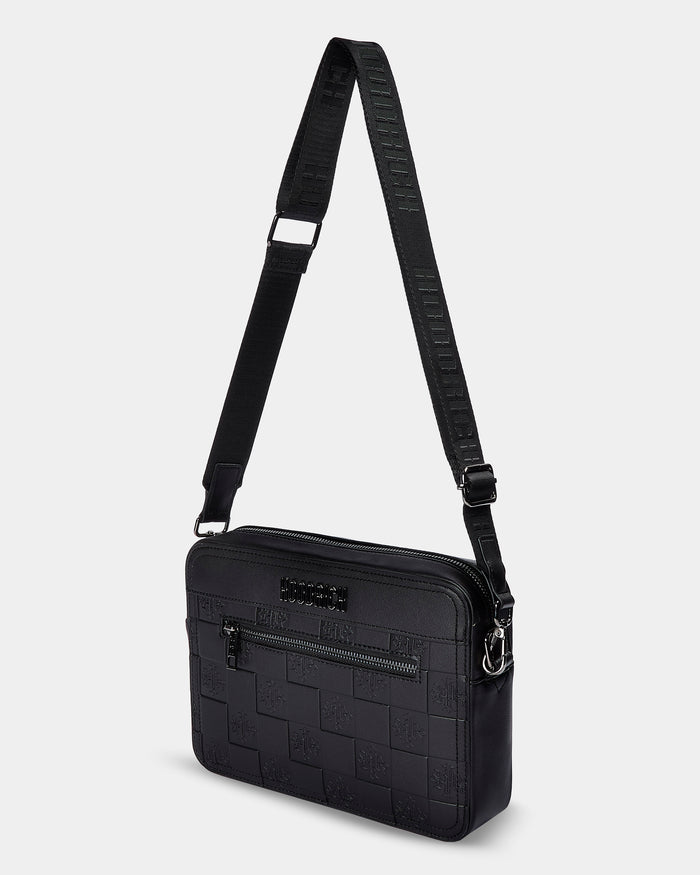 Black crossbody bag with textured pattern on a light gray background