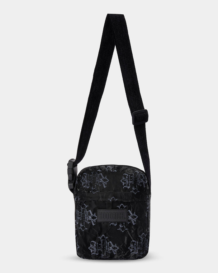 Black patterned crossbody bag on a light gray background