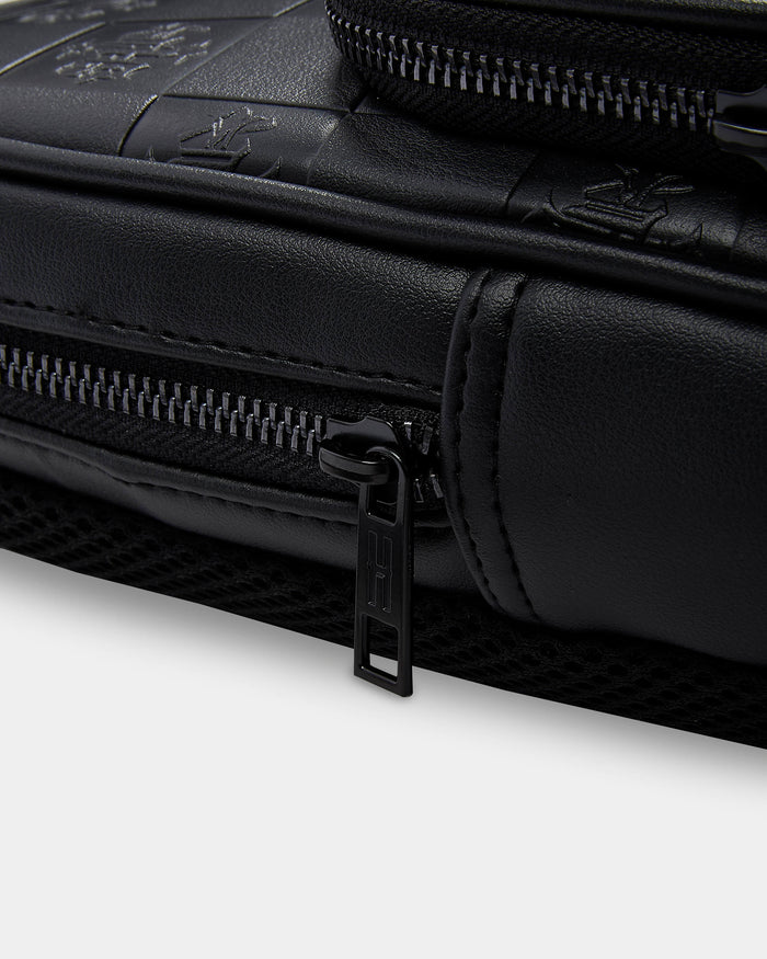 Close-up of a black leather bag with zippers on a white background