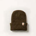 Pladra Watch Cap Beanie in olive green with folded brim, orange logo patch, made in USA, shown on white background.