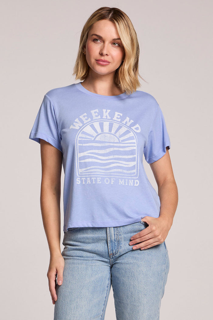 Front view of a woman wearing the Chaser  Weekend State Of Mind Tee and jeans on a neutral background