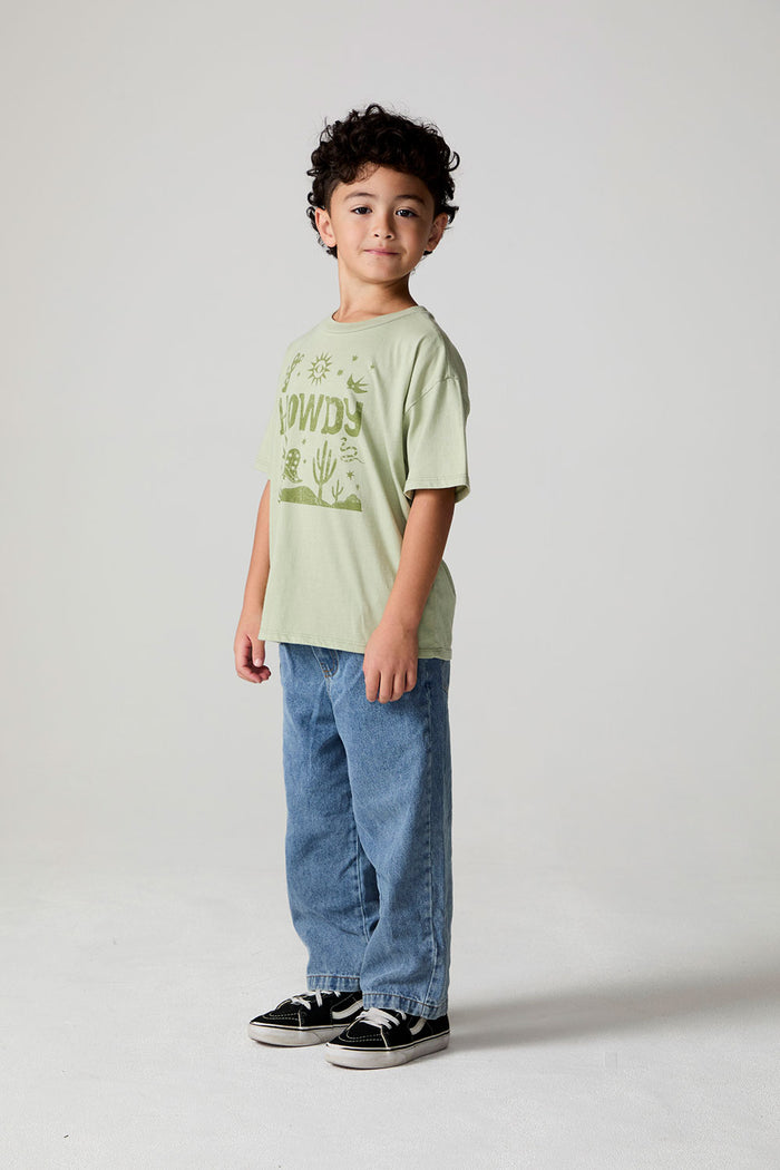 Full body side angle view of a boy wearing the Chaser Western Time Tee on a neutral background