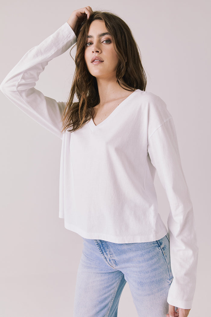 Side view of woman wearing Chaser’s Whiskey White Long Sleeve showing relaxed fit and sleeve detail on a plain background