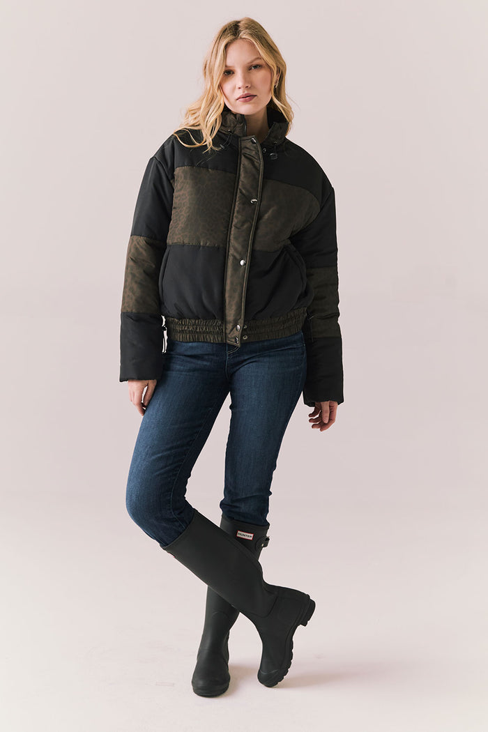 Full body view of Chaser Brand Whistler Leopard and True Black Puffer Jacket paired with dark denim and black boots