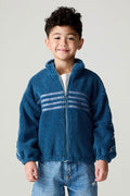 Frontview of a boy wearing the Chaser White Bolts Boys Jacket and bluejeans on a neutral background