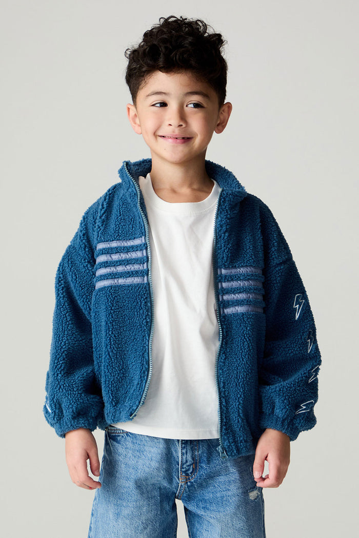 Front view of a boy wearing the Chaser White Bolts Boys Jacket with a white tee shirt underneath