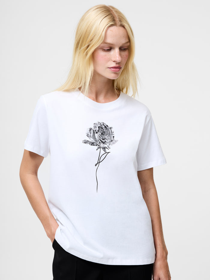 A woman wearing a white regular fit T-shirt with a black graphic print rose, short sleeves and a crew neck.