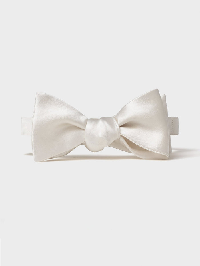 White satin butterfly bow tie, tied, front-facing on a light grey background.