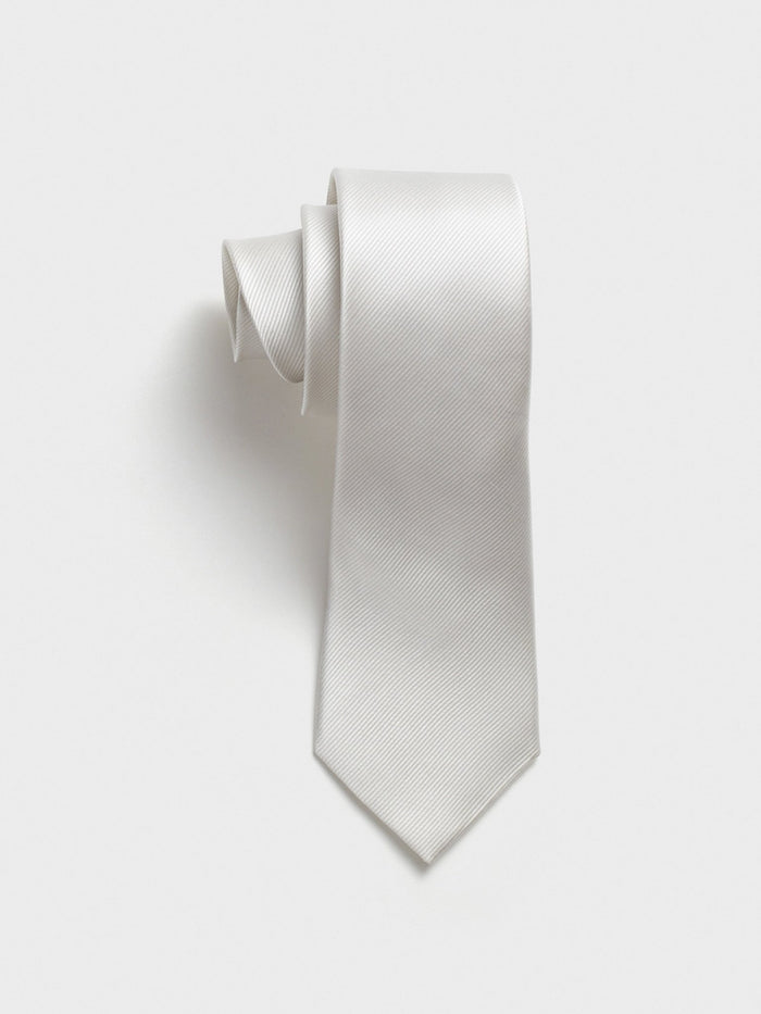 White silk necktie with textured twill, rolled on a plain background