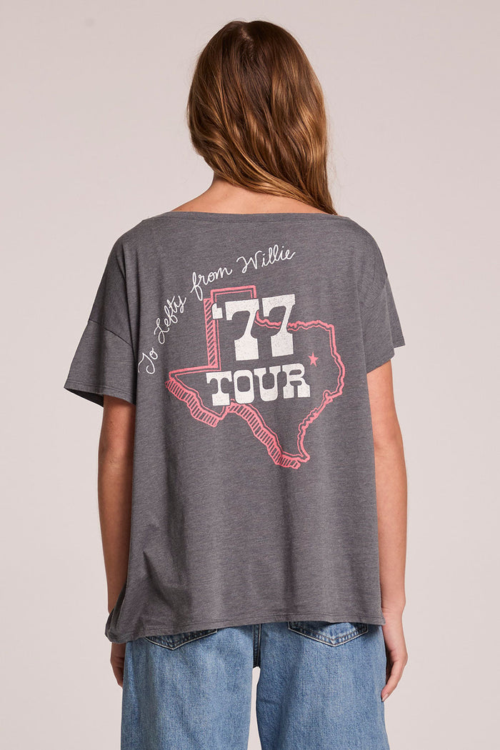 Back view of a woman wearing the Chaser  Willie Nelson 77 Tour Tee on a neutral background