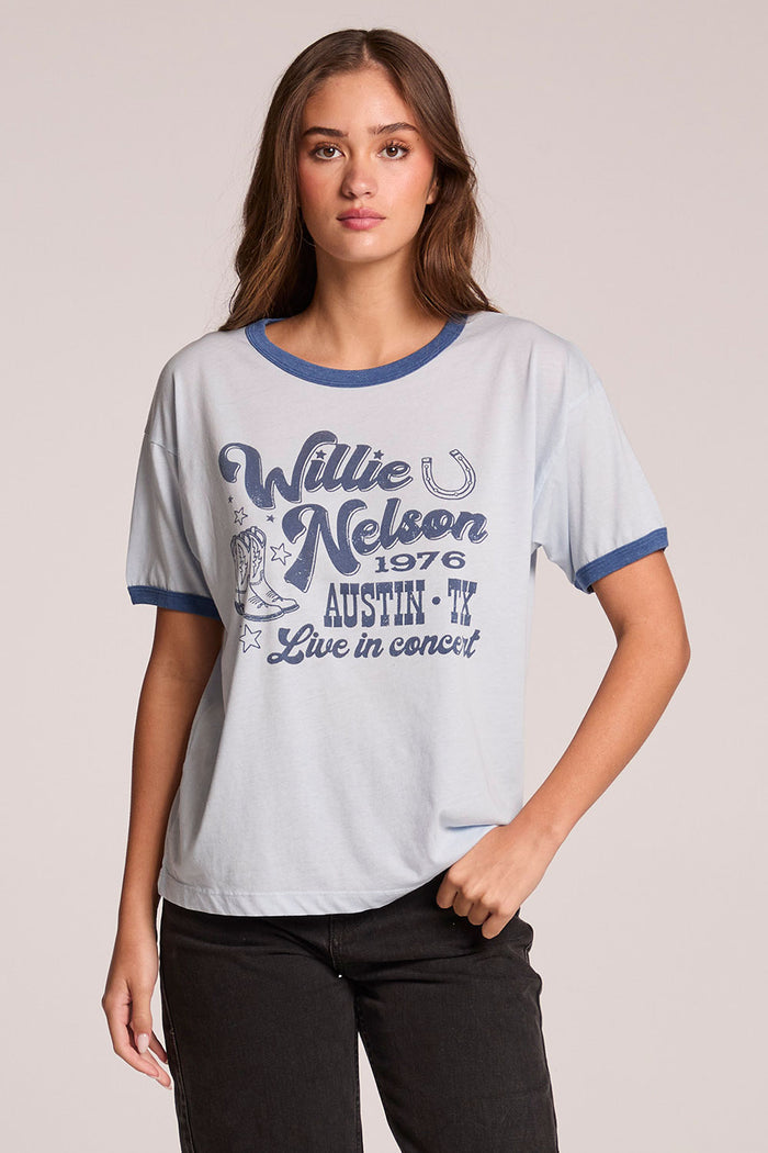 Front view of a woman wearing the Chaser  Willie Nelson Austin 1976 and black pants on a neutral background