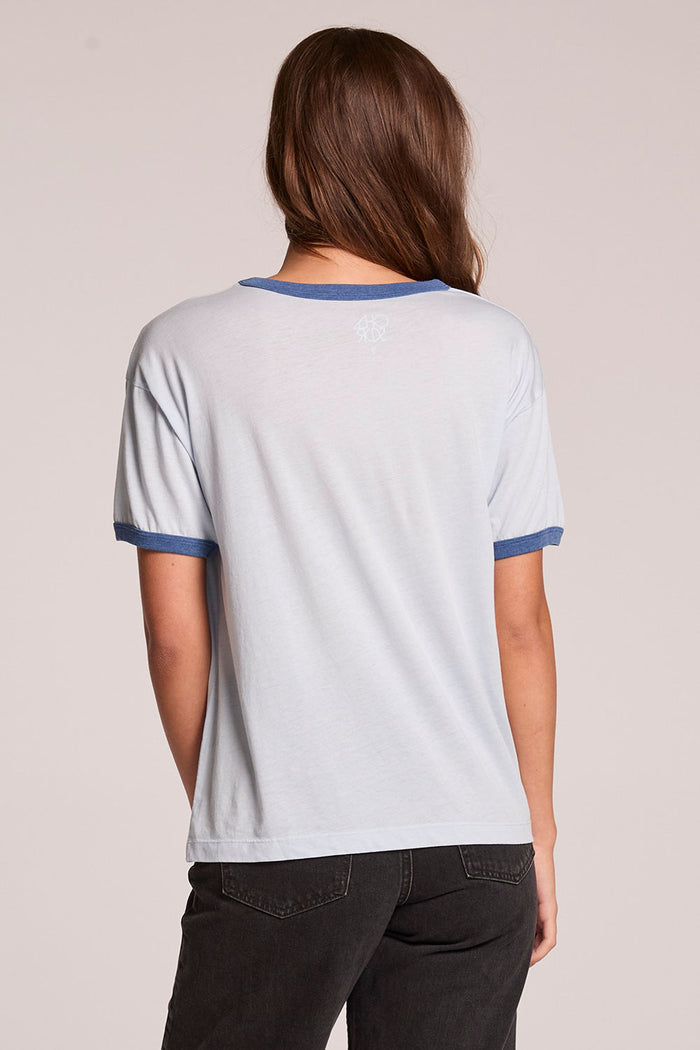 Back view of a woman wearing the Chaser  Willie Nelson Austin 1976 on a neutral background