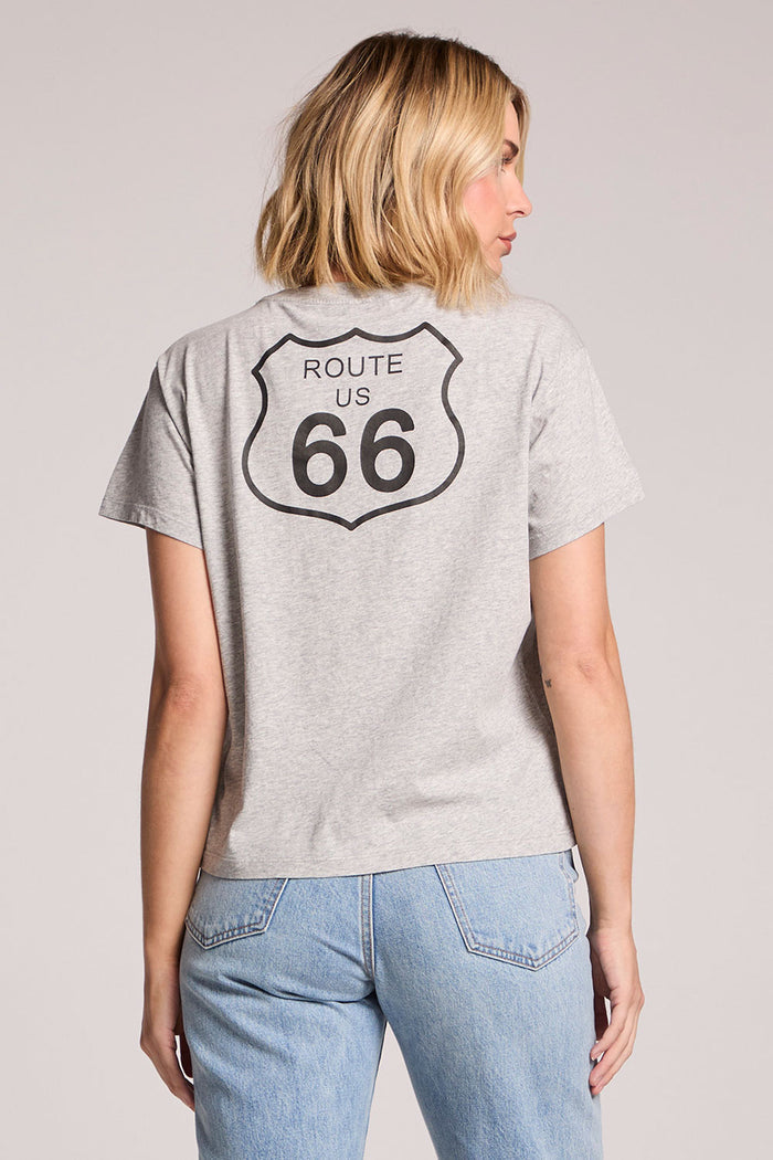 Back view of a woman wearing the Chaser Willie Nelson On The Road Again Tee on a neutral background