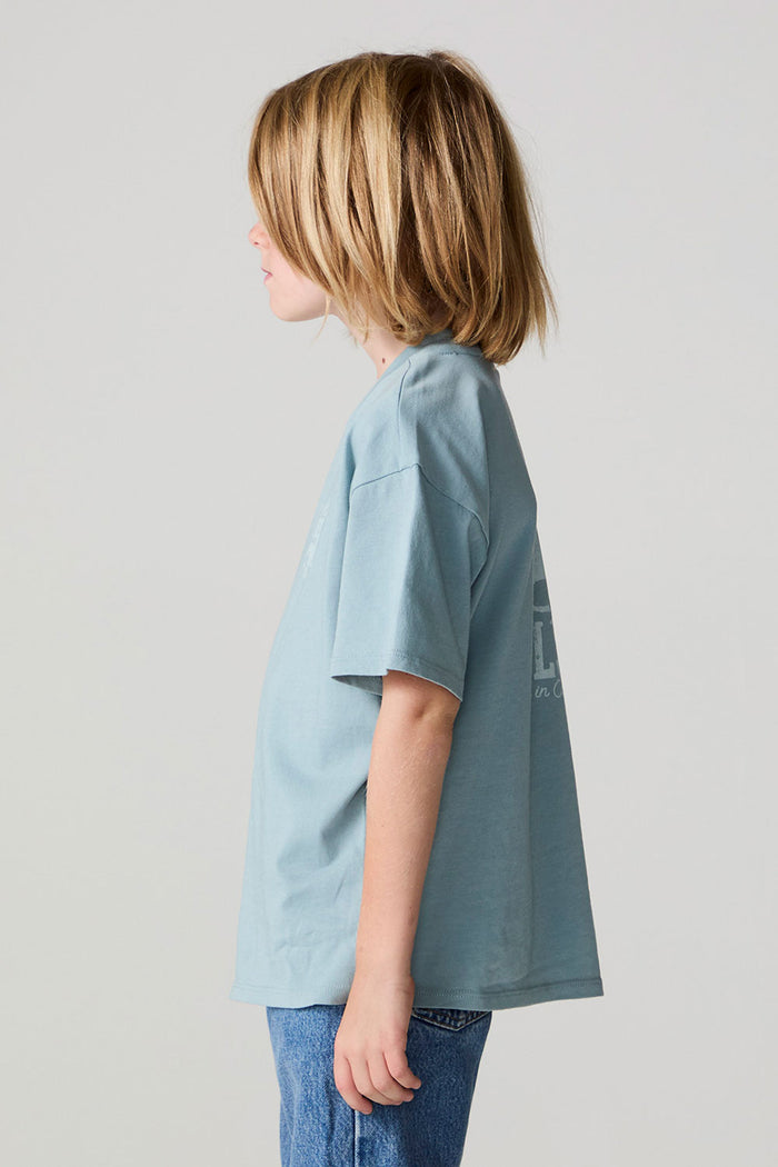Side view of a boy wearing the Chaser Willie Nelson Rider Tee on a neutral background