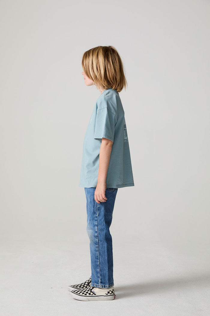 Full body side view of a boy wearing the Chaser Willie Nelson Rider Tee on a neutral background