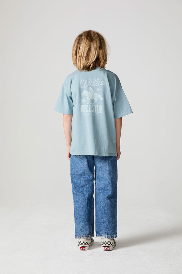 Full body back view of a boy wearing the Chaser Willie Nelson Rider Tee on a neutral background