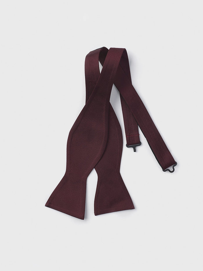 Wine satin self-tie butterfly bow tie, untied and laid flat on a grey background