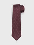 Wine silk necktie with white pin dots, rolled at the top on a white background