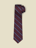 Wine-colored necktie with diagonal blue stripes, rolled on a cream background.