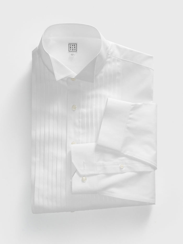 White pleated-front tuxedo shirt, flat lay, folded with wing collar and French cuffs