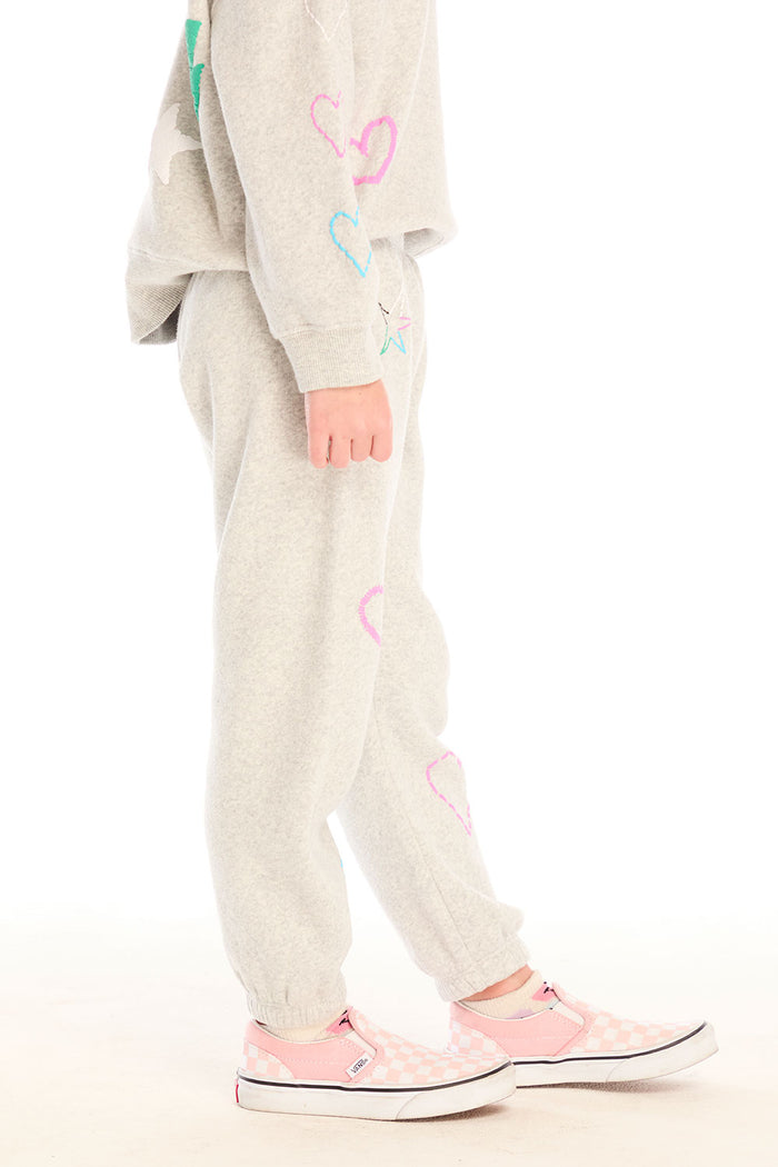 Side view of girl wearing Chaser’s light gray Winter Love Pants with colorful designs on a white background