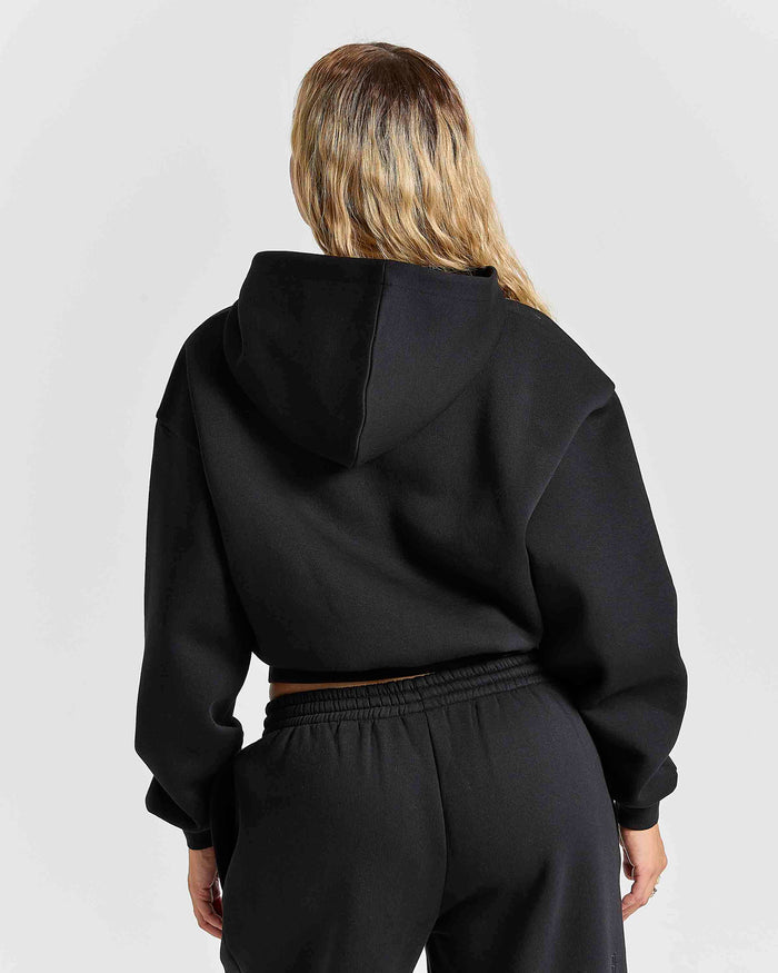 Displays a women wearing the Black 'Hoodrich' branded women's Aegis Full Tracksuit