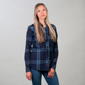 A woman with long blonde hair poses against a light gray background, wearing the Women's Breeze Shirt in Ocean Blue and blue jeans. She looks at the camera with a neutral expression.