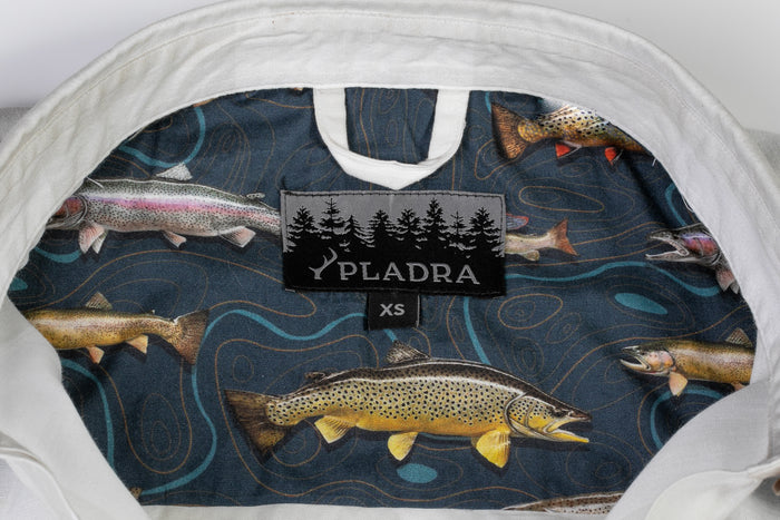 Close-up of Women's Breeze Shirt-Whisper Grey by Pladra, with fish-patterned collar lining and XS label with trees.