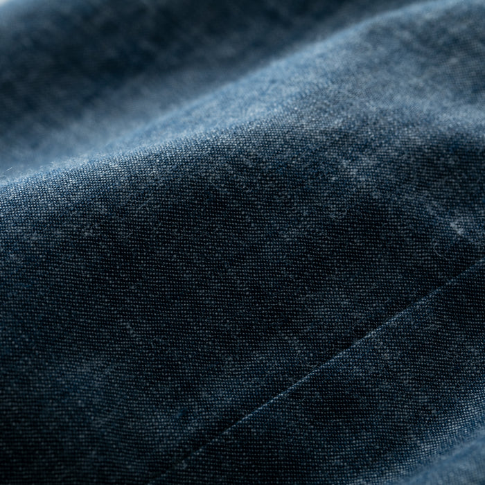 Close-up of the Women's Cascade Shirt in Indigo Blue Chambray, highlighting its fine texture, visible weave, subtle color variations, and softly wrinkled surface for a flexible, comfortable feel.
