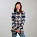 A woman with straight brown hair stands against a light background, wearing the Women's Every Day Flannel Shirt- Banff Blue and blue jeans, hands clasped in front of her and smiling slightly.
