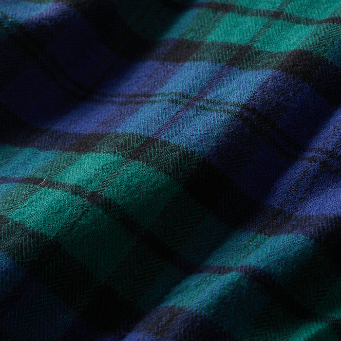 A close-up of the Men's Every Day Flannel Shirt in Bolinas Blue, showing soft Portuguese flannel with a green, blue, and black plaid pattern. The slightly wrinkled texture highlights the quality weave—perfect for a classic men's or outdoor shirt.