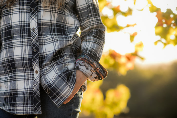 Woman in Pladra Women's Every Day Flannel Shirt–Butte Blue, hand in pocket, outdoors in autumn sunlight.