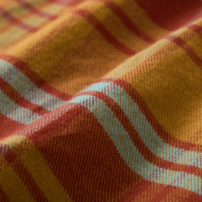A close-up of the Women's Every Day Flannel Shirt- Cottonwood Orange shows its soft, premium cotton fabric with an orange, yellow, and light blue plaid pattern—ideal texture and design for stylish comfort.