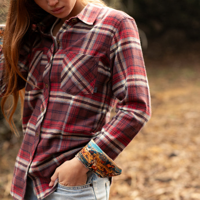 Woman outdoors in Pladra's Women's Every Day Flannel Shirt in Harvest Red, hand tucked in her pocket.