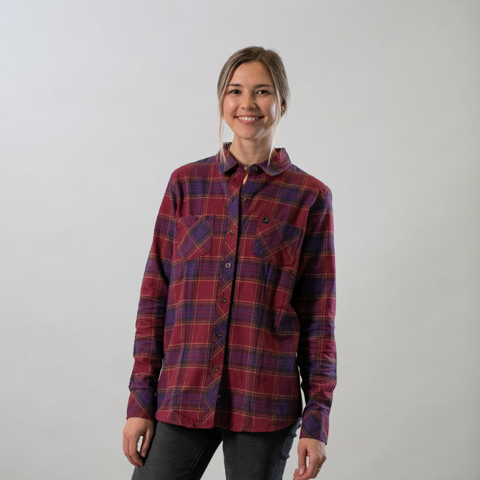 A smiling person wears the Pladra Women's Every Day Flannel Shirt in RK Plum Red against a light gray background.