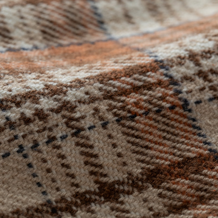 A close-up of the Women's Fireside Flannel in Cattail Tan, showcasing its soft, woven plaid fabric in brown, beige, orange, and cream with a warm texture and classic checked pattern—ideal for cozy outdoor wear.