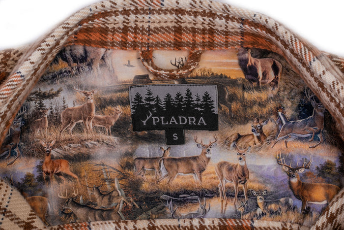 Close-up of the Women's Fireside Flannel- Cattail Tan collar in brown and orange plaid, made from heavyweight Portuguese flannel, featuring a forest scene with deer lining and a black Pladra tag.