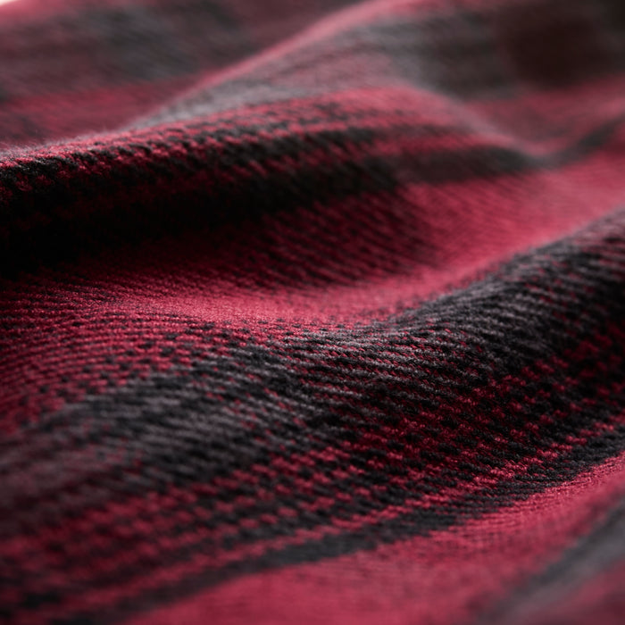 Close-up of the Women's Fireside Flannel in Deadwood Red, showcasing heavyweight Portuguese fabric with alternating red and black stripes, softly draped for a textured, cozy appearance.