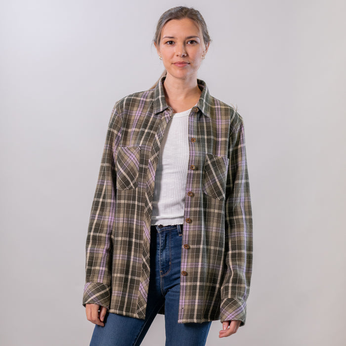 A woman wears the Pladra Women's Fireside Flannel in Grove Green over a white top and jeans against a plain background.