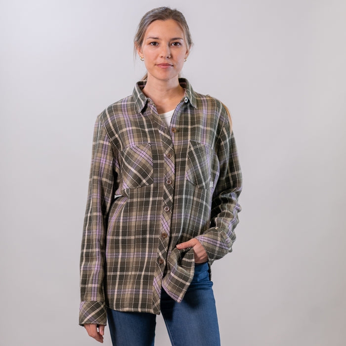 A woman wears the Pladra Women's Fireside Flannel in Grove Green with jeans, standing against a light background.