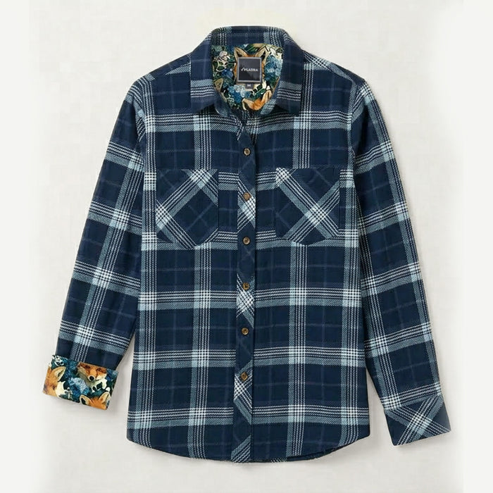 The Women's Fireside Flannel in Laguna Blue is a heavyweight, long-sleeve plaid shirt with two chest pockets and a floral inner collar and cuffs, shown on a simple light background.