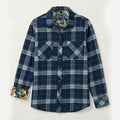 The Women's Fireside Flannel in Laguna Blue is a heavyweight, long-sleeve plaid shirt with two chest pockets and a floral inner collar and cuffs, shown on a simple light background.