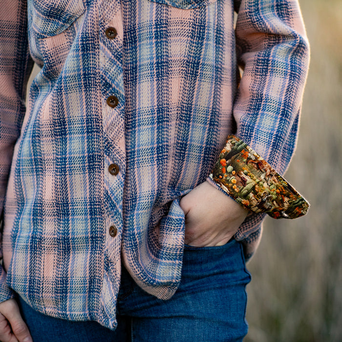 Woman in Pladra Women's Fireside Flannel–Lily Pink, cuff showing a colorful mushroom pattern.