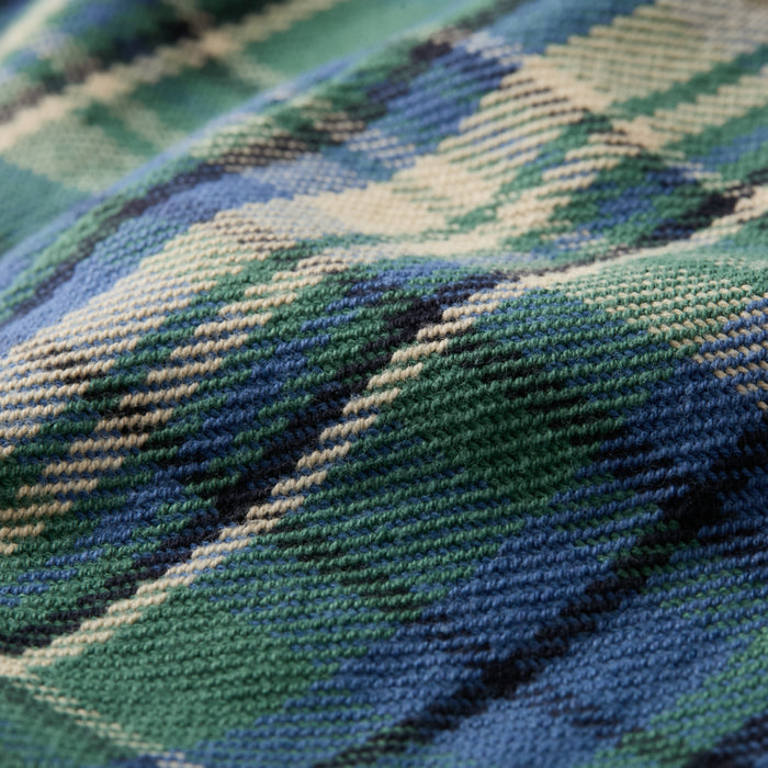 A close-up of the woven texture and subtle folds in the Women's Fireside Flannel- Primrose Green, featuring a blue, green, cream, and black plaid pattern from heavyweight Portuguese flannel.