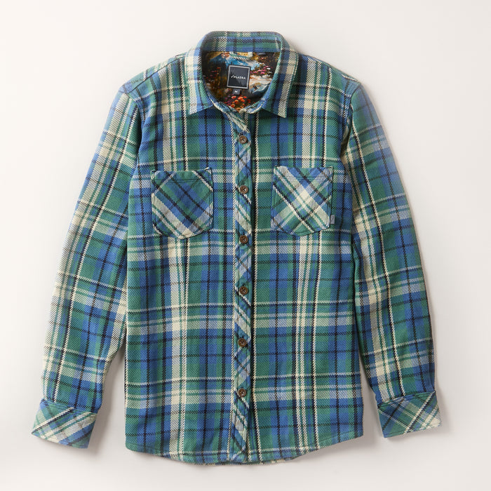The Women's Fireside Flannel in Primrose Green is a long-sleeve, heavyweight Portuguese flannel shirt with blue, green, and white plaid. It features two chest pockets with diagonal plaid and is shown laid flat on a light background.
